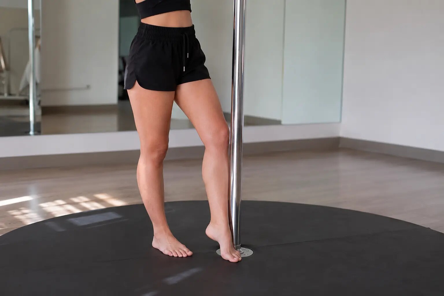 Bare feet gripping the pole during a beginner pole dancing class